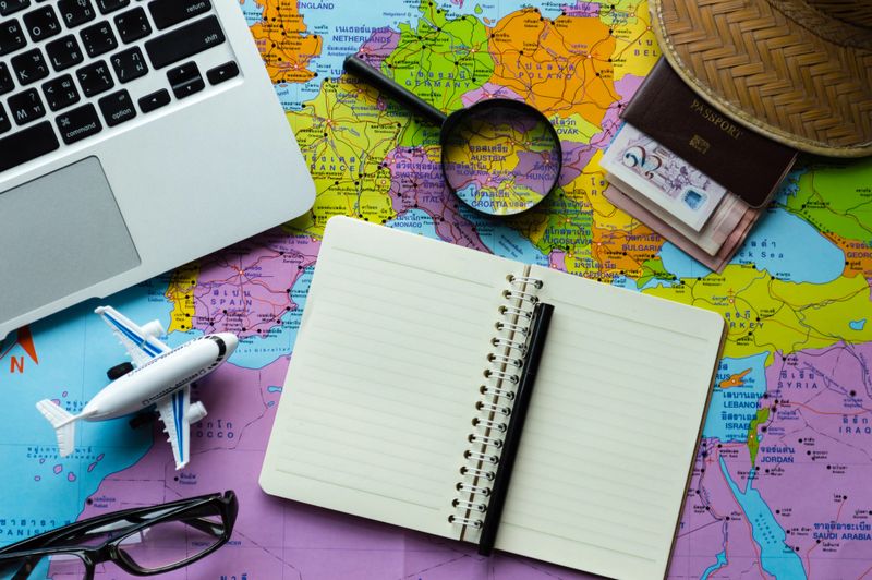 Go on an adventure! The map and the passport on a wooden table. Top view Travel concept.