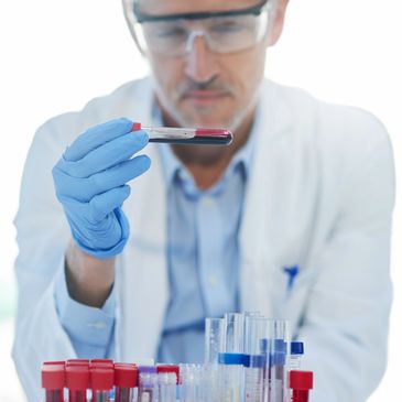 Scientist examining a blood sample in a test tube in the lab.