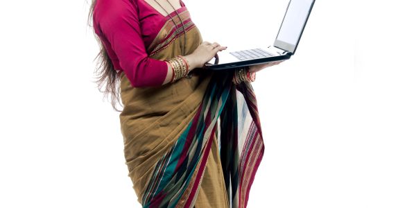 Woman in traditional saree using a laptop.