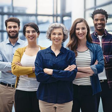 Confident diverse group of professionals standing together with arms crossed.