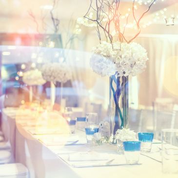 Elegant wedding table setting with white flowers and blue glasses.
