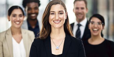 Confident businesswoman leading a diverse team with smiles.