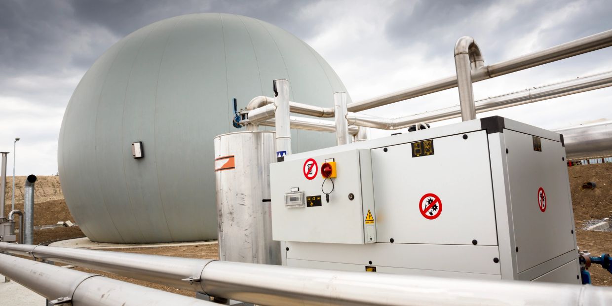 Industrial gas storage spherical tank with pipes and control unit.