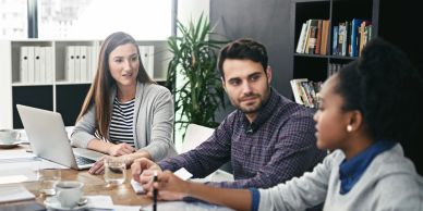 Three colleagues engaged in a meeting at a modern office.