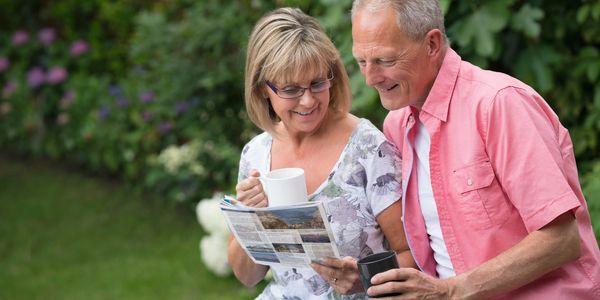 Older couple enjoying reading outdoors.