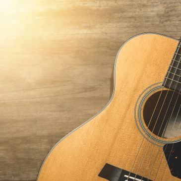 Close-up of an acoustic guitar with sunlight.