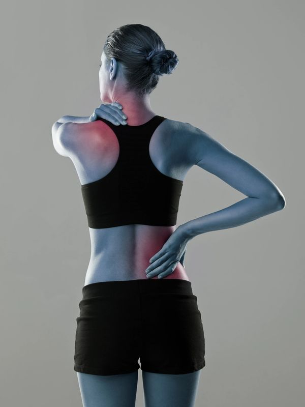 Woman experiencing shoulder and lower back pain, highlighted in red.