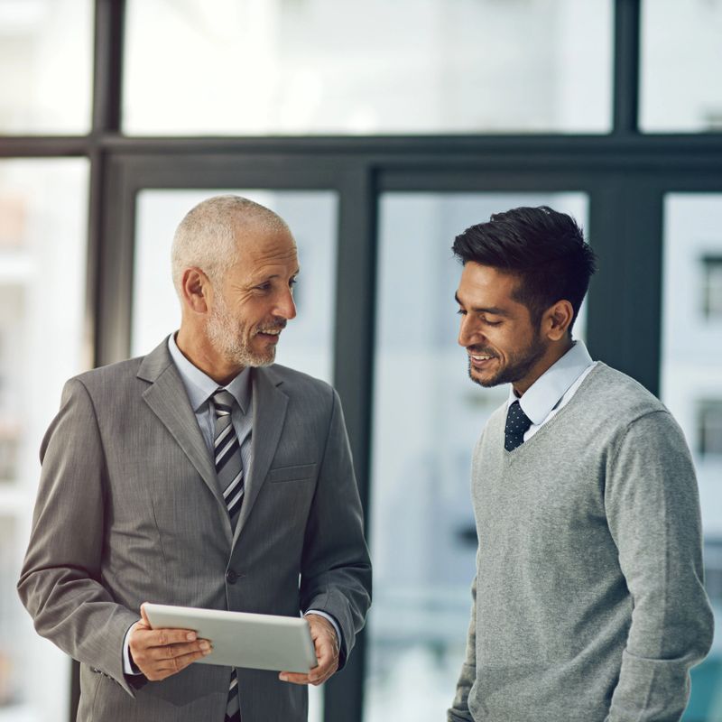 Cropped shot of two businessmen looking at a digital tablet in their office