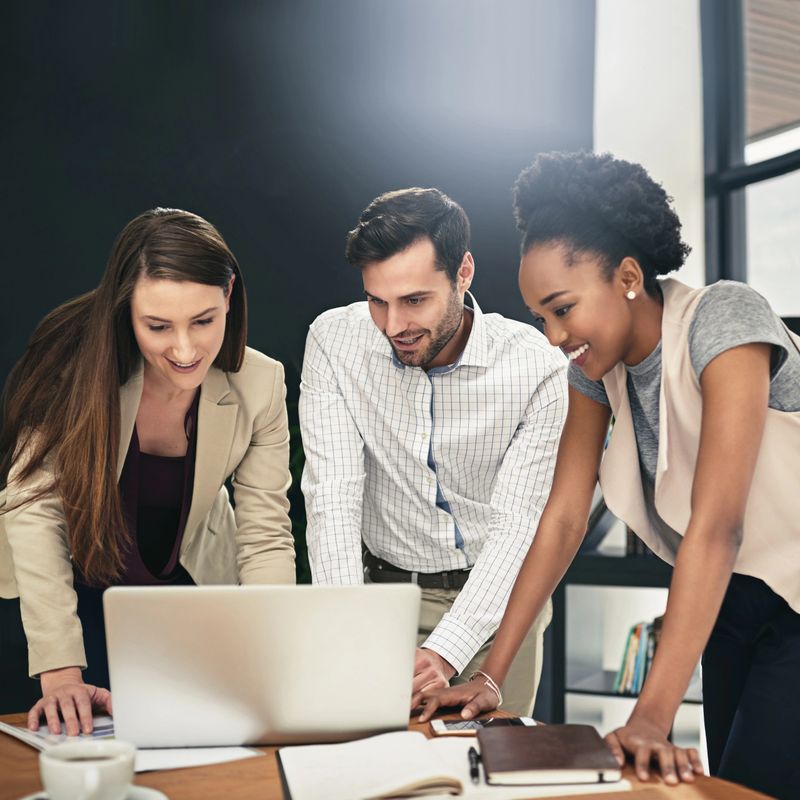 Shot of a team of businesspeople using a laptop together at work