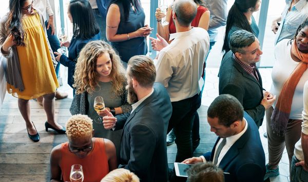 People socializing and enjoying drinks at a lively networking event.