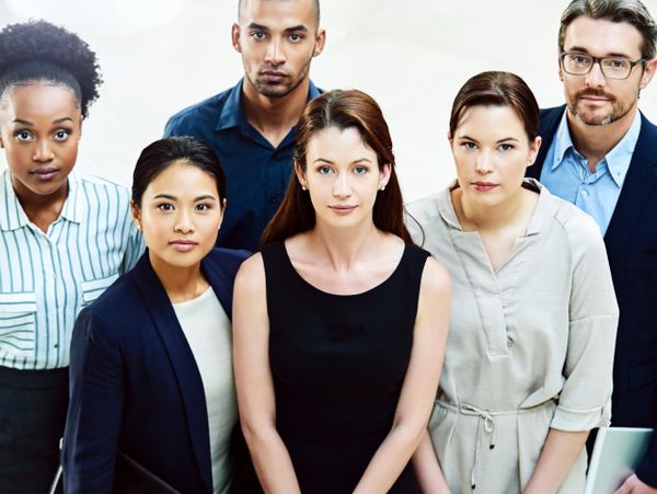 Diverse group of six professionals posing confidently together.