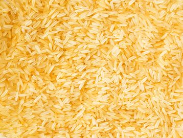 Close-up of uncooked golden parboiled rice grains.