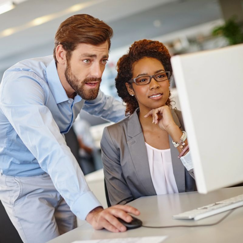 Shot of two coworkers using a computer together at work