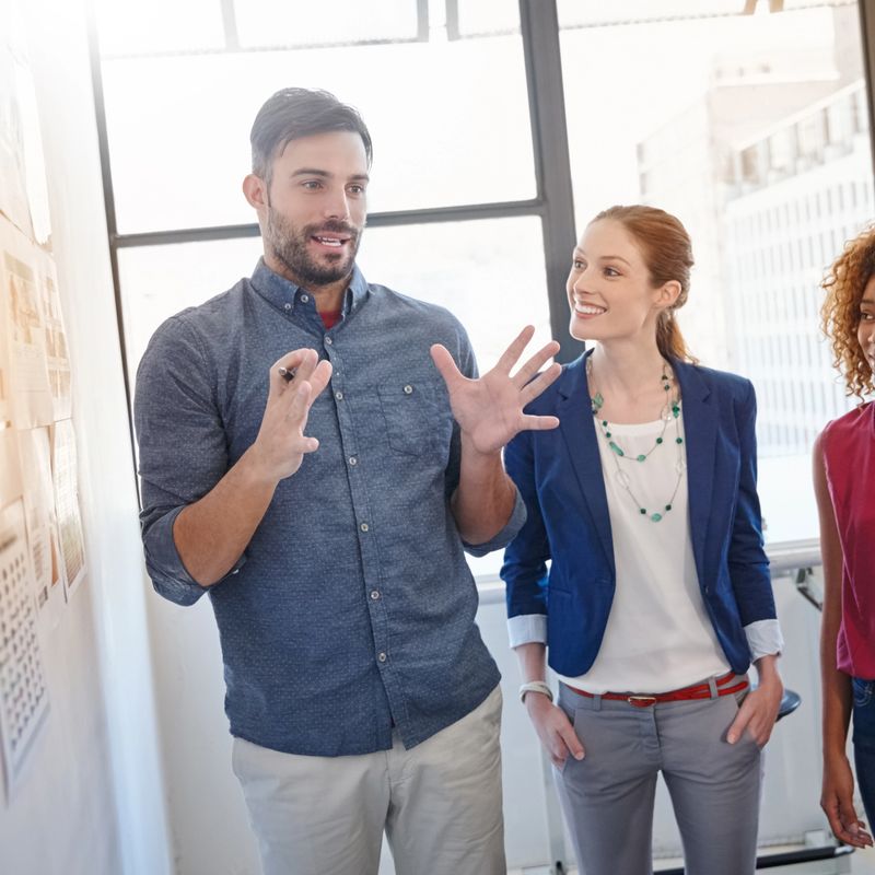 Shot of a group of businesspeople listening to a colleague's presentation in the office