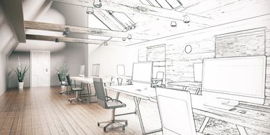 Modern office space with computers and ergonomic chairs under exposed wooden beams.