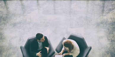 Two professionals in a modern office discussing with a tablet.