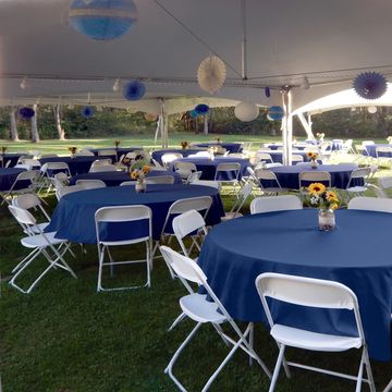 Outdoor event setup with blue tablecloths and white chairs. White chair rentals in Tehachapi. 