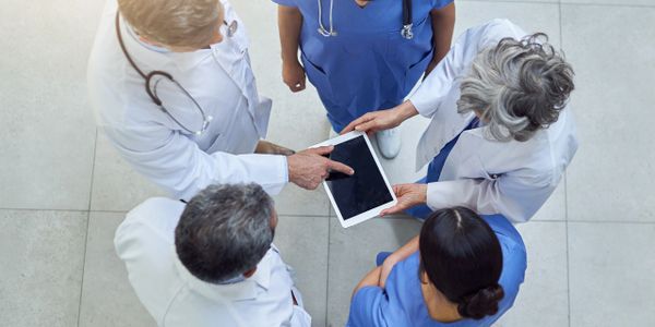 Medical team reviewing information on a tablet together.