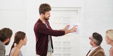 Man presenting ideas to colleagues in a meeting room.
