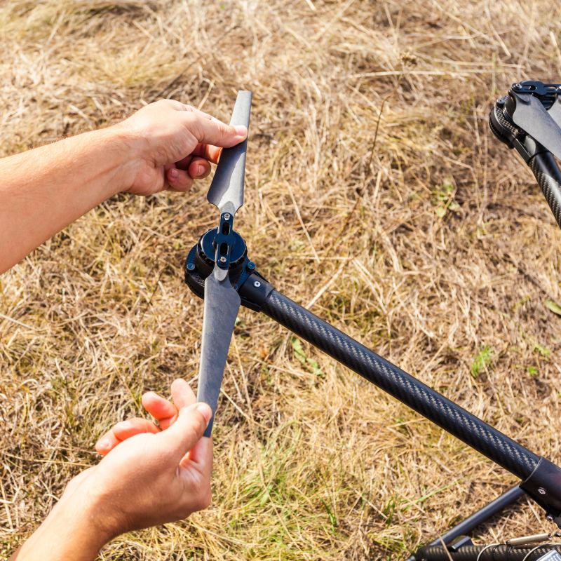 The process of setting up a copter before flight. The man makes all the necessary adjustments before the flight on the drone.