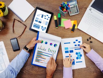 Business team analyzing charts and graphs at a desk.