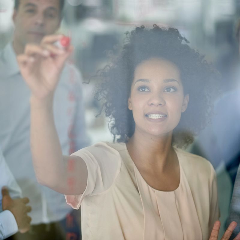 Shot of a group of creative businesspeople plotting out details on a glass wall