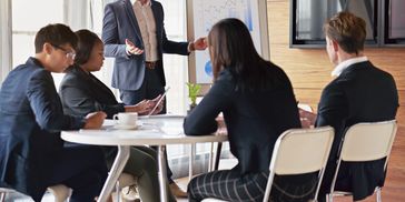 Business team in a meeting, discussing ideas around a table.
