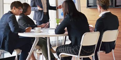 Business meeting with a group discussing around a table.