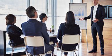 Business meeting with a man presenting quarterly growth charts to colleagues.