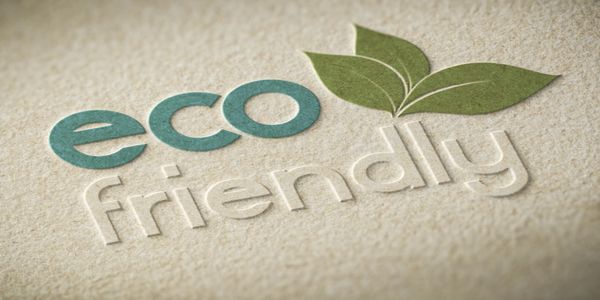 Eco friendly logo with green leaves on textured paper background.