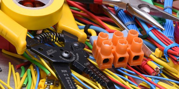Electrical tools and colorful wires arranged for wiring work.