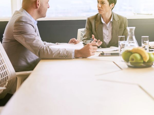 Two business professionals engaged in a discussion at a conference table.