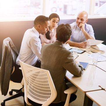 Four professionals engaged in a focused business meeting around a table.