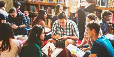 Students studying together in a library group setting.
