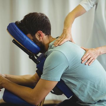 Man receiving shoulder massage on massage chair.