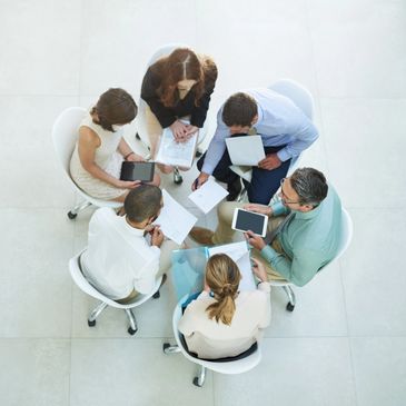 Group of professionals collaborating around a glass table.
