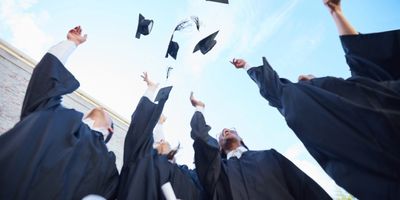 Group of people having graduated and throwing their caps in the air