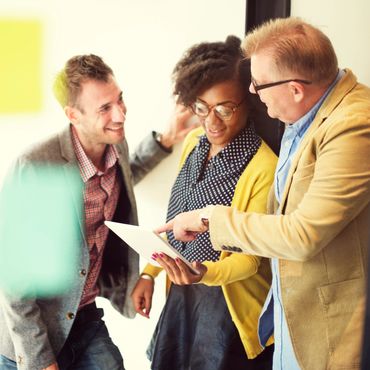 Three colleagues discussing work using a tablet.