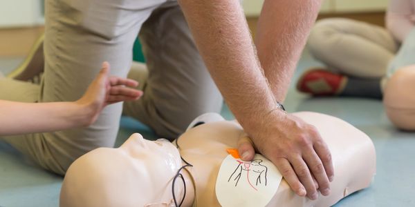 Person practicing CPR on a training mannequin.