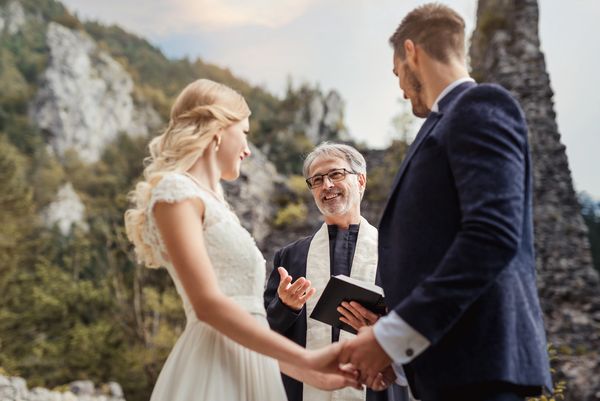 Bride and Groom standing with officiant at a scenic outdoor Colorado mountain ceremony