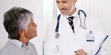 Doctor consulting a senior female patient with a friendly smile.