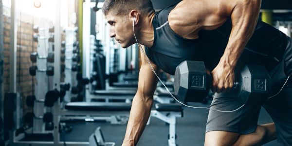 Athlete lifting dumbbells in gym.