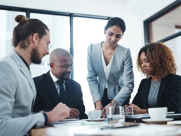 Four professionals collaborating in a modern office meeting.