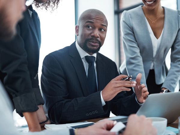 Businessman in suit explaining a point during a meeting.
