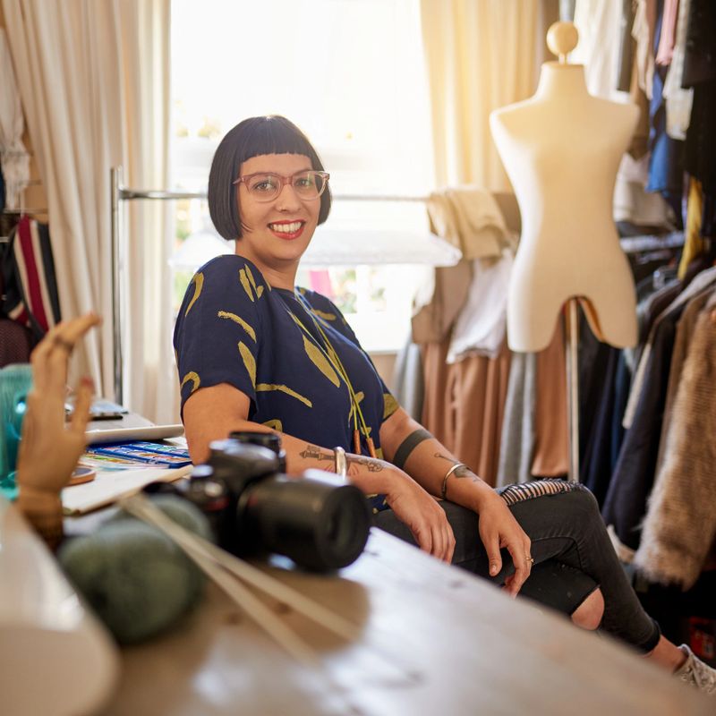 Portrait of a stylish young designer sitting in her eclectic studio