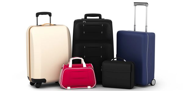 Five different colored suitcases grouped together.