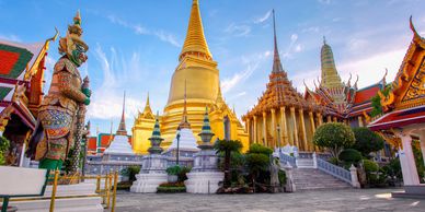 Golden temple complex with ornate statues under a clear blue sky.