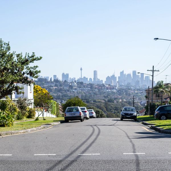 Residential street overlooking the Sydney city skyline on a clear day.