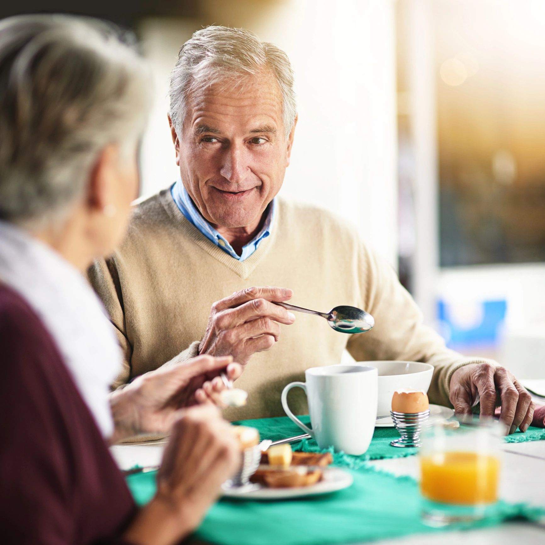 Elderly couple enjoying breakfast together, sharing a warm moment.