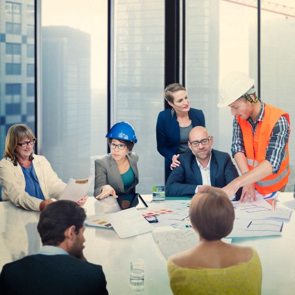 Diverse professionals discuss construction plans in a modern office.